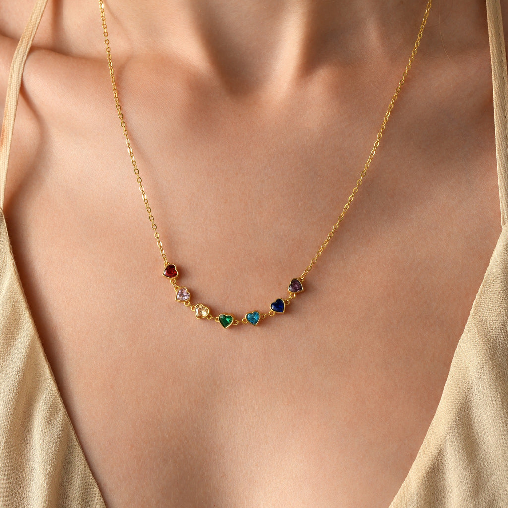 Personalised family heart birthstone necklace in gold vermeil, with seven colourful heart-shaped stones.