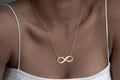 Infinity name necklace worn at the neckline