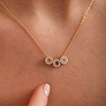 Square close-up of three round halo birthstones on a gold vermeil family necklace