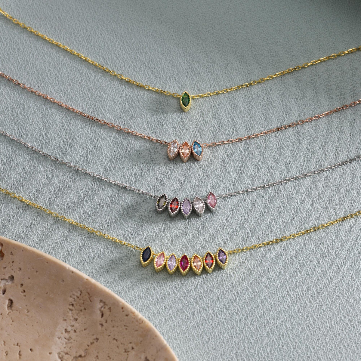 Family birthstone necklaces showing different numbers of marquise-shaped stones