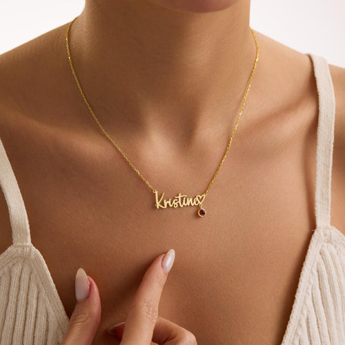Gold-coloured Kristina name and birthstone necklace worn at the neckline