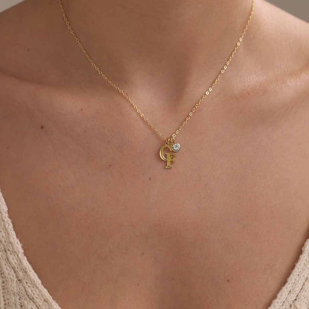 Personalised two initial necklace shown first in a gold finish with a birthstone, followed by a silver finish without a birthstone.