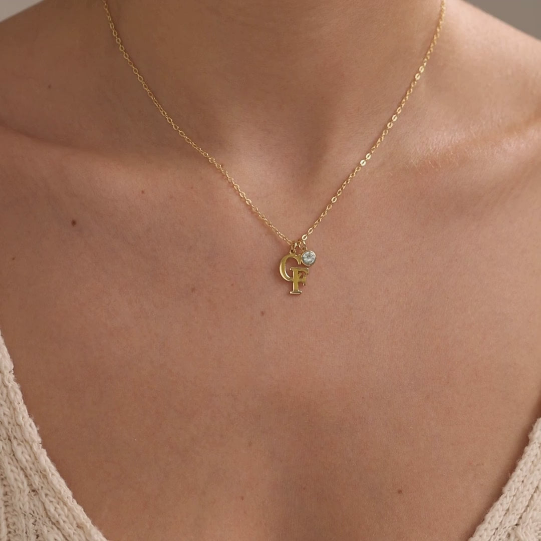 Personalised two initial necklace shown first in a gold finish with a birthstone, followed by a silver finish without a birthstone.