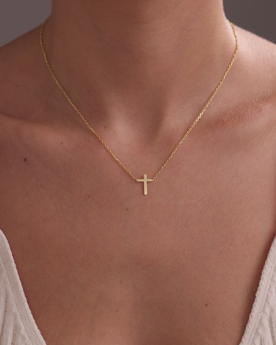 Gold vermeil centred cross necklace worn on the neckline, showing its natural movement and scale