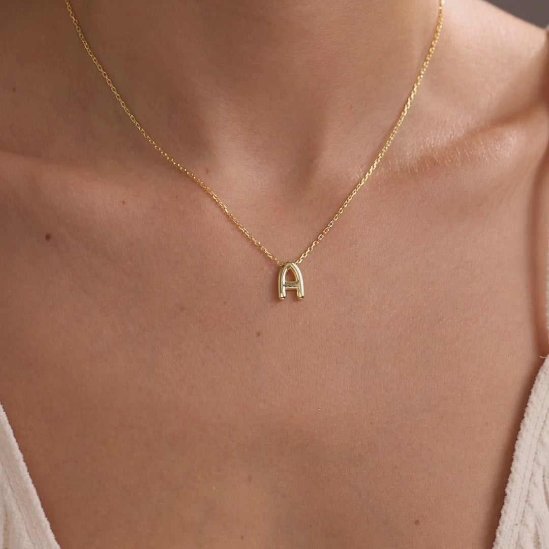 Personalised 3D bubble initial necklace in a gold finish, showing A and M letter pendants worn on a delicate chain.