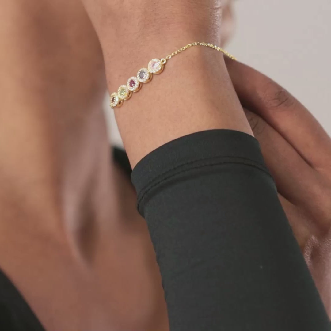 Gold vermeil family birthstone bracelet with round halo settings worn on a wrist, showing the stones and chain from different angles