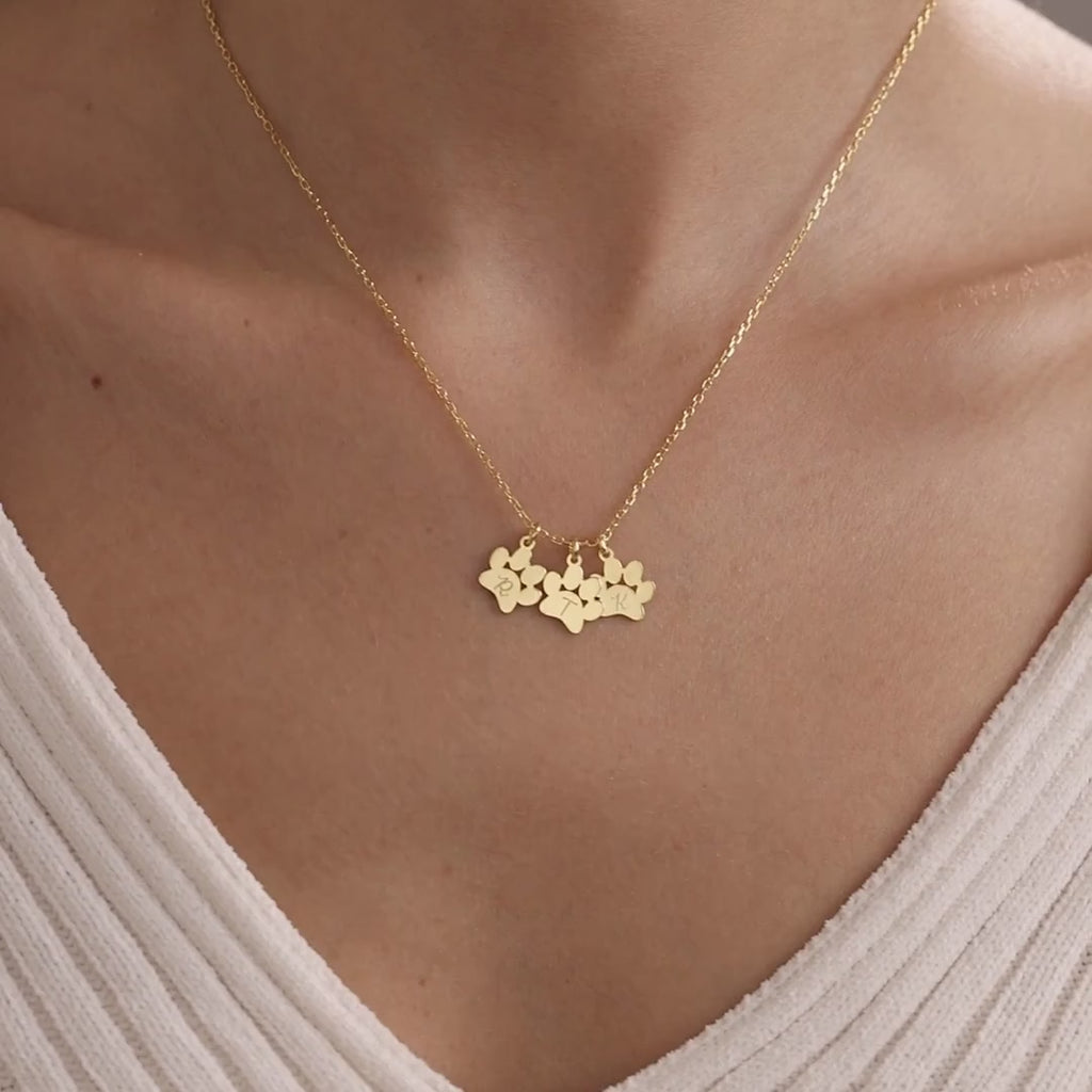 Personalised gold pet paw charm necklace worn on a model