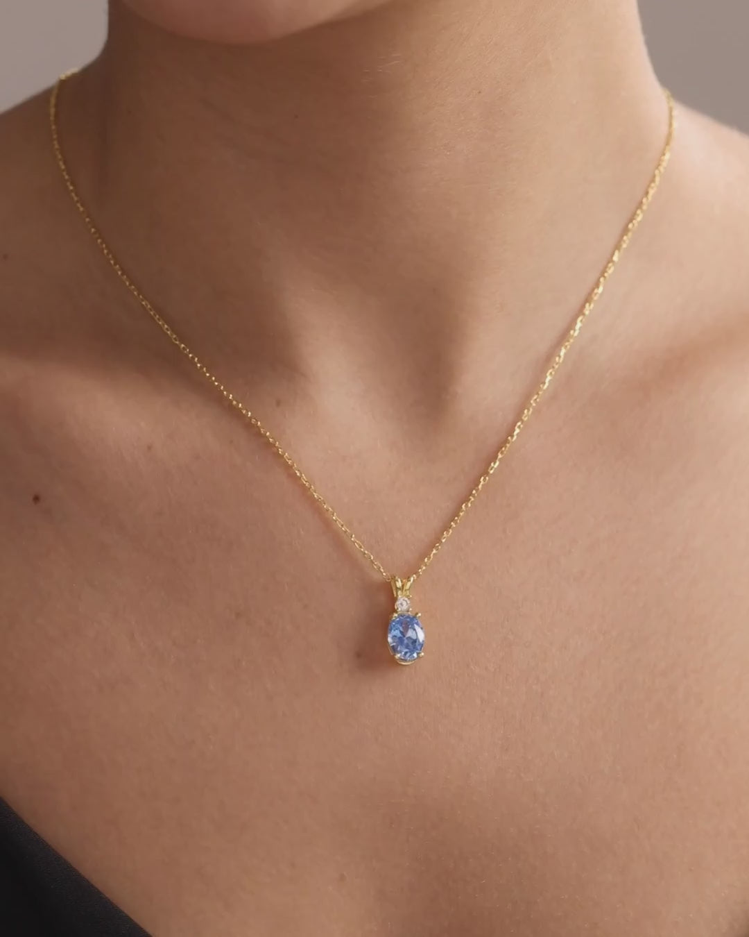 Oval blue birthstone pendant necklace in gold vermeil, showing natural movement and scale when worn