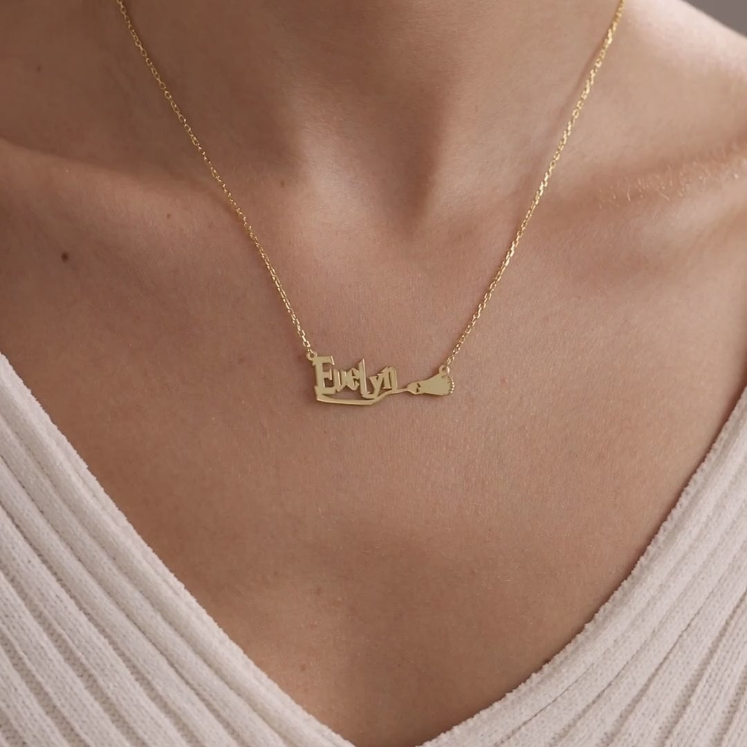 Gold personalised broom name necklace worn on a model
