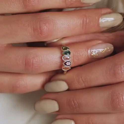 Gold vermeil family birthstone ring with coloured teardrop stones worn on a hand