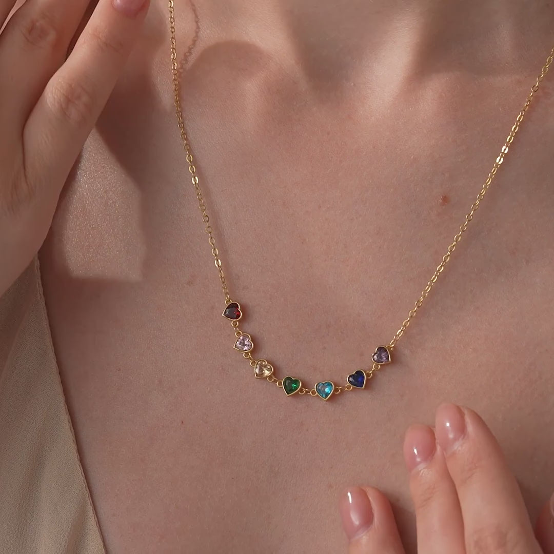 Gold vermeil family heart birthstone necklace shown on a model, with the coordinating bracelet appearing later in the video.